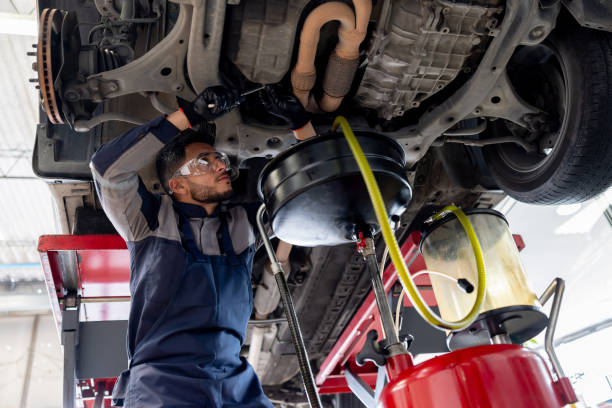 Mechanic performing an oil change under a vehicle in a Salem, Oregon auto repair shop specializing in American cars