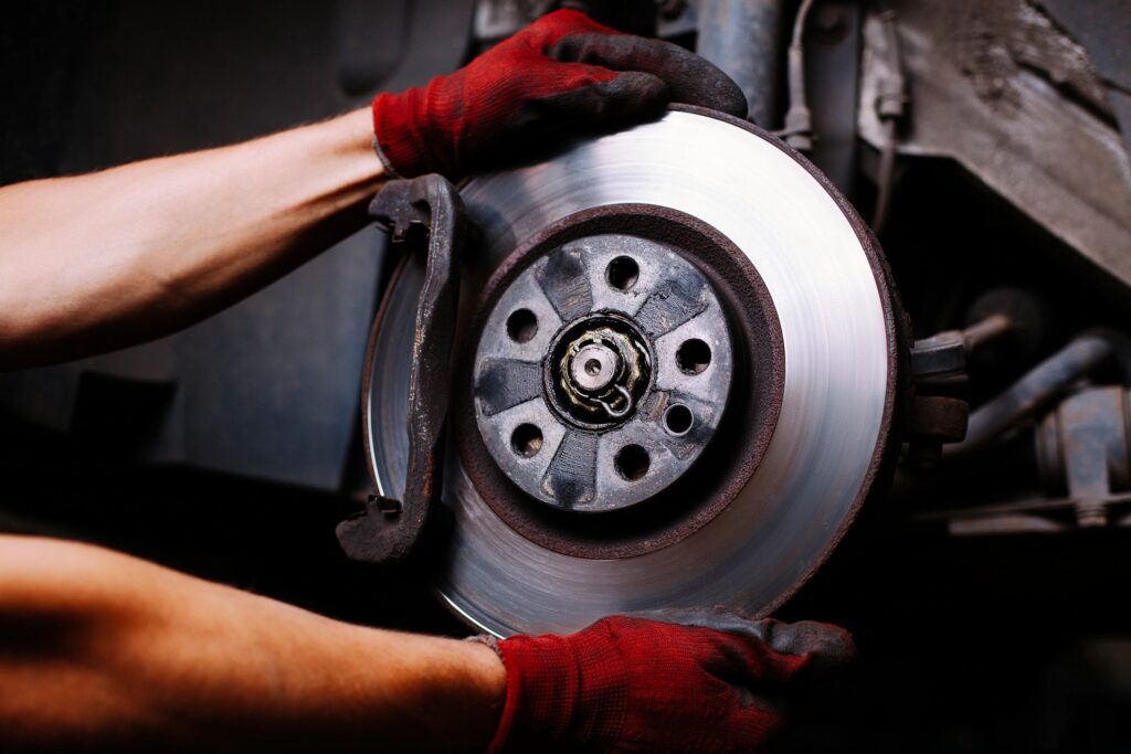 Close-up of a car brake rotor and caliper, showing detailed components of a vehicle's braking system.