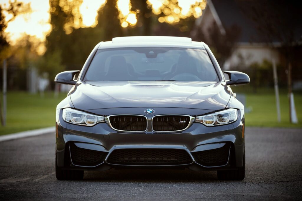 Close-up of a sleek BMW parked on a road, highlighting its luxury design and performance features.